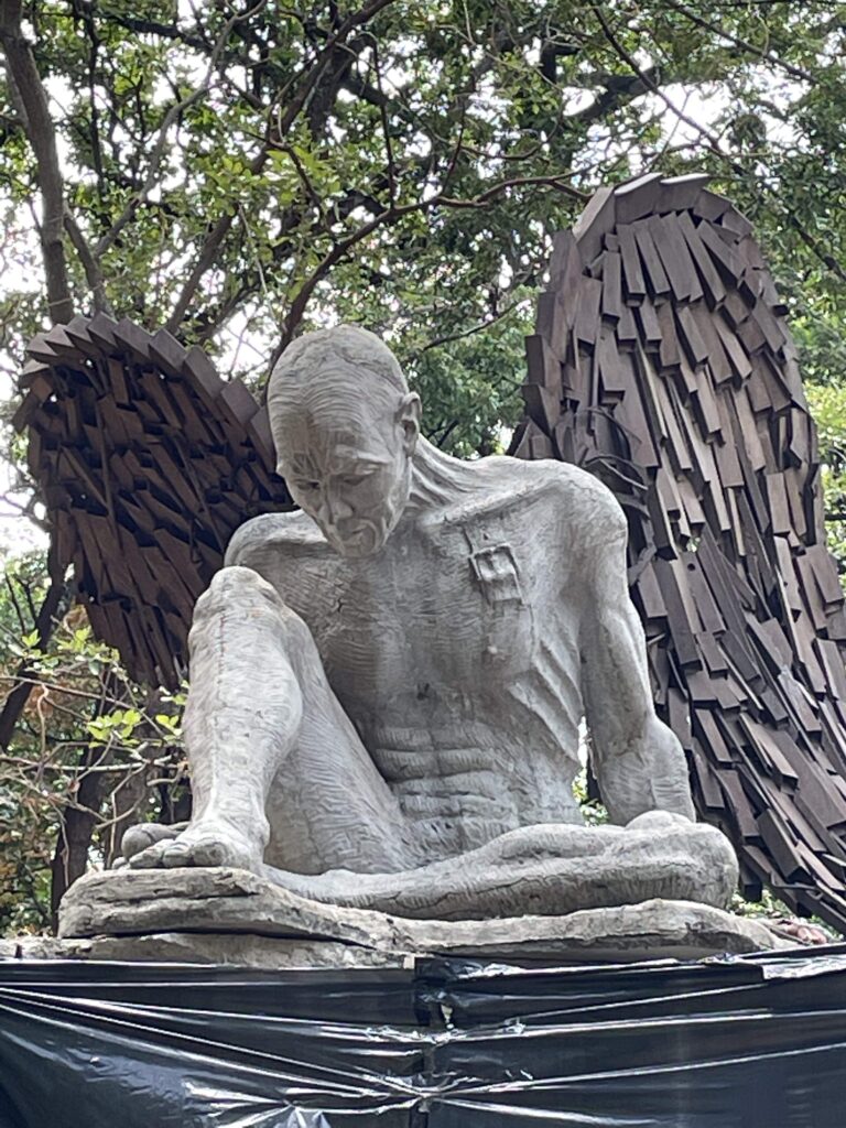 escultura icaro, hombre con expresion de tristeza con dos alas